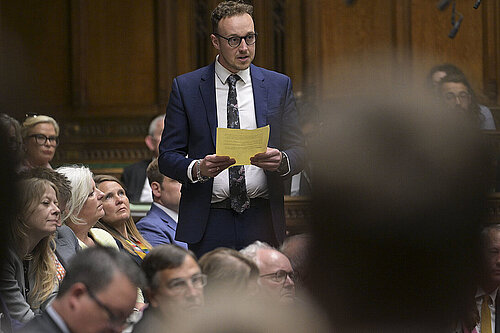 Adam standing up in Parliament