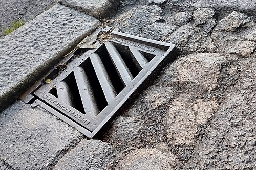 Pothole damage around street drain gully