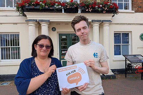 Cllr Nathan Hunt and Cllr Jo Harvey holding a sign that reads “We’re backing Ask for Angela”