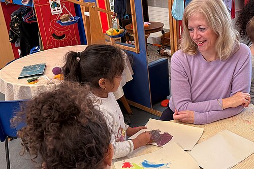 Liz Jarvis MP sat with a child in a school