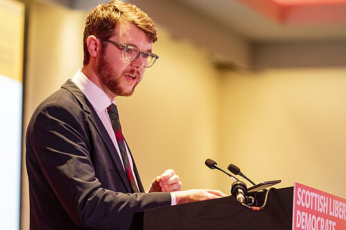 Daniel O'Malley at a podium speaking.