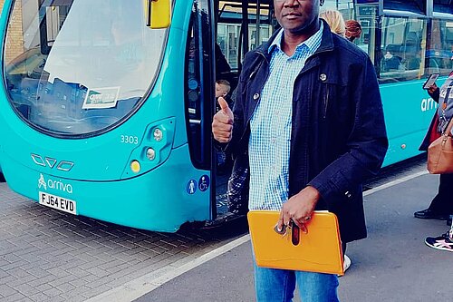 Cllr Ben Adewale next to a bus