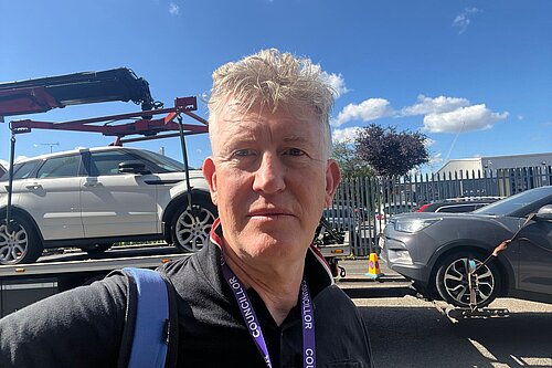 Cllr Jonathan Oxley (Hanger Hill) in front of cars being towed away.